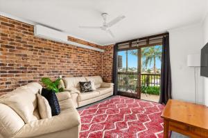 ein Wohnzimmer mit 2 Sofas und einer Ziegelwand in der Unterkunft Toowong Villas in Brisbane