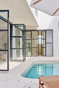 a house with a swimming pool and windows at Casa Mona - Luxury 3 Bedroom Villa in Bingin in Uluwatu