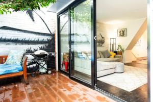 Wohnzimmer mit Glastür und Sofa in der Unterkunft Green Door Gem - Your Stylish Retreat in South Melbourne in Melbourne