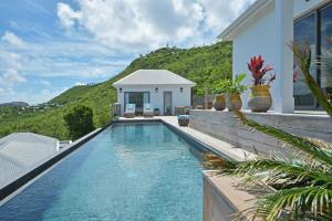 a swimming pool in front of a house at Villa Vogue 5 Bedroom Villa in Saint Barthelemy