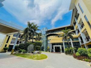 um edifício com palmeiras em frente em LM METRO HOTEL em Zamboanga