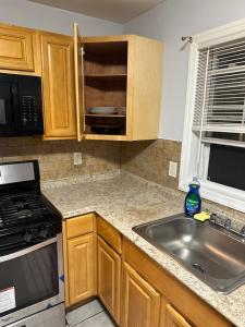 a kitchen with a sink and a stove top oven at Fidelia Amethyst Room, King Bed and Twin Bed with Private Bathroom Minutes From Newark Liberty International Airport and Newark Penn Station in Irvington