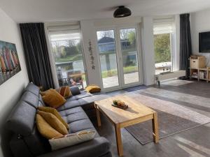 a living room with a couch and a table at Villa Sunlight Comfortable Vacation Home in Makkum