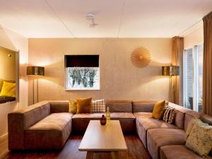 a living room with a couch and a table at Spacious Retreat, Vlagtwedde in Vlagtwedde