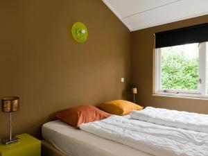 a bedroom with two beds and a clock on the wall at Spacious Retreat, Vlagtwedde in Vlagtwedde