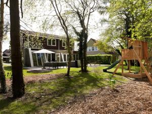 a playground in a yard with a house at Spacious Retreat, Vlagtwedde in Vlagtwedde