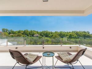 a patio with two chairs and a table at Villa in Novigrad with Pool and Sea Views in Bužinija