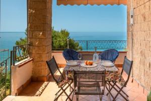 stół i krzesła na balkonie z widokiem na ocean w obiekcie Le terrazze di Acciaroli - Happy Rentals w mieście Acciaroli