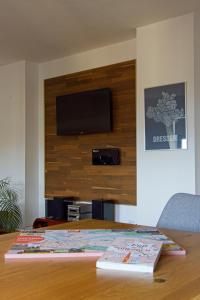 a table with two books and a television on a wall at Neustadt-Aussicht - große Wohnung mit Balkon in Dresden