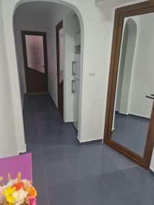 a hallway with a mirror and a box of flowers at Apartament Eric in Mangalia +1 photo