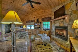 salon z kominkiem w drewnianym domku w obiekcie Cozy Mountain Cabin w mieście Ellijay