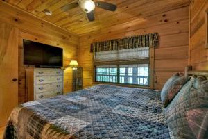 - une chambre avec un lit et une télévision à écran plat dans l'établissement Cozy Mountain Cabin, à Ellijay