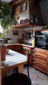 a kitchen with a table and a stove top oven at Chambre agréable à proximité de Disneyland Paris JO in Nanteuil-lès-Meaux
