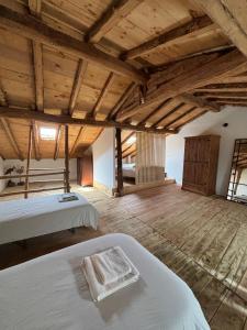 Habitación grande con 2 camas y techos de madera. en La Cabaña del Risco, en Ligos