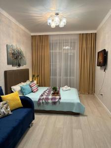 1 dormitorio con 1 cama y 1 sofá azul en ЖК ALPAMYS, en Astana