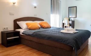 a bedroom with a large bed with orange pillows at Guest House Maritimo in Sukošan