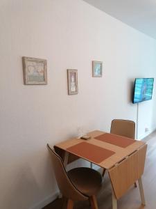 a wooden table and two chairs in a room at Ferienwohnung in Veitshöchheim in Veitshöchheim