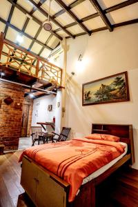 ein Schlafzimmer mit einem großen Bett mit orangefarbener Bettwäsche in der Unterkunft Palm Mansion Boutique Suites in George Town