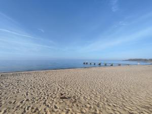 a sandy beach with a pier in the water at Litet och mysigt semesterboende in Ystad