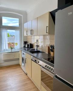 a kitchen with a stove top oven next to a window at 2-Zimmer Zentral in Ferdinandshof, WLAN Modern in Ferdinandshof +21 photos
