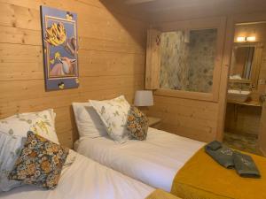 two beds in a room with wooden walls at Chalet La Renarde in Villars-sur-Ollon
