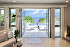 a living room with a couch and a view of the ocean at Crystal Besso Shirahama in Shirahama