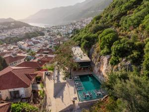 a house with a swimming pool on a mountain at Yoga House Kaş in Kaş