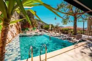 a pool with chairs and a palm tree at Yoga House Kaş in Kaş