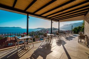 a row of tables and chairs on a balcony overlooking the ocean at Yoga House Kaş in Kaş