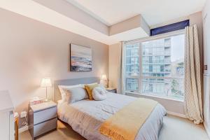 a bedroom with a bed and a large window at Prime City Pad 2 Bedroom with CN Tower View in Toronto