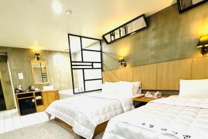 釜山にあるYeonsan In Hotelのベッド2台と鏡が備わるホテルルームです。