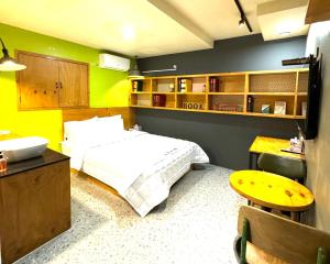 釜山にあるYeonsan In Hotelのベッドルーム1室(白いベッド1台付)と黄色い壁