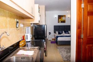 - une cuisine avec évier et un lit dans une chambre dans l'établissement WEST SUITE NEWLY FURNISHED APARTMENT, à Nairobi