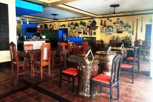a restaurant with tables and chairs in a room at Puerto Del Sol Beach Resort and Hotel Club Bolinao Pangasinan in Bolinao