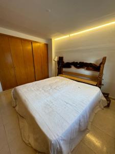 a bedroom with a large bed with a wooden headboard at Hilda's King Suite Room in Roses