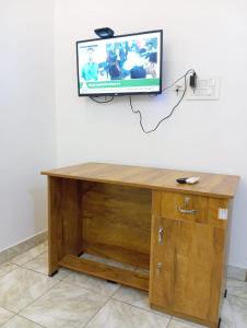 a wooden desk with a tv on a wall at Thekkumpuram Tourist Home in Malappuram