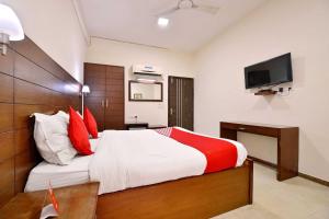um quarto com uma cama e uma televisão na parede em Super OYO Jaipur Casa Near Sawai Man Singh Stadium em Jaipur