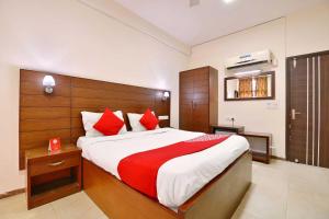 um quarto com uma cama grande e almofadas vermelhas em Super OYO Jaipur Casa Near Sawai Man Singh Stadium em Jaipur