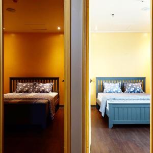 een slaapkamer met 2 bedden en een spiegel bij Sensi Stay in Garapan
