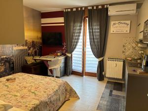 een slaapkamer met een bed, een bureau en een raam bij Studio Flat Policlinico G B Rossi Borgo Roma in Verona