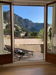 a room with a window with a view of a mountain at Luxury Top Floor Apartment with terrace - Beaulieu Sur Mer in Beaulieu-sur-Mer