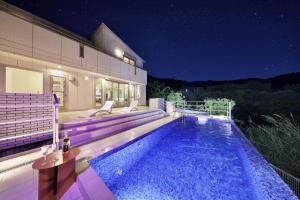 a house with a swimming pool at night at Crystal Besso Shirahama in Shirahama