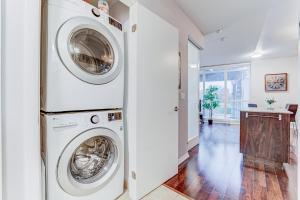uma lavandaria com duas máquinas de lavar e secar roupa em Prime City Pad 2 Bedroom with CN Tower View em Toronto