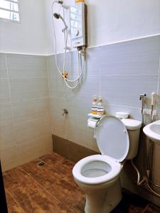 a bathroom with a toilet and a shower at Muji Homestay Ria Heights Tawau in Tawau