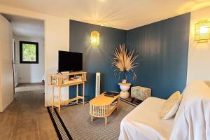 a living room with a bed and a tv at La Baie des Mangues 1 - Baba Figue - Nibou in Saint-Paul
