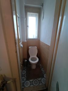 a small bathroom with a toilet and a window at Garden Apartman Malvazinky in Prague