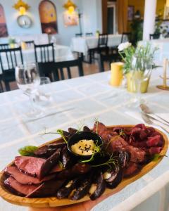 ein Teller mit Fleisch und Würstchen auf dem Tisch in der Unterkunft Gościniec in Myszęcin