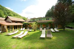 un groupe de chaises longues sur une pelouse devant une maison dans l'établissement Le Saint Barnabe & Spa - near Guebwiller, à Buhl