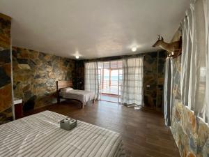 ein Schlafzimmer mit einem Bett in einem Zimmer mit Steinwänden in der Unterkunft Sal Marina Restaurante y Cabañas in Salina Cruz