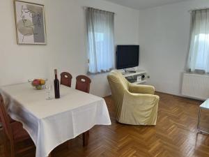 a dining room with a table and chairs and a television at Medulin Burle A4 1 in Medulin